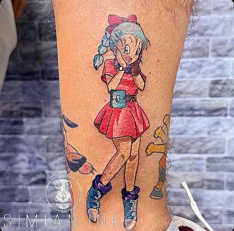 Tatuaje a color de Bulma de Dragon Ball con vestido rojo en la pierna